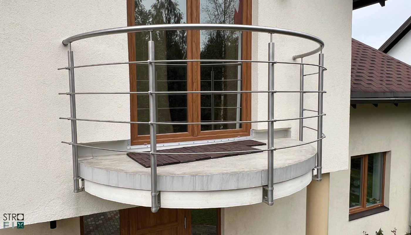 Reliņu margas uz izliekta balkona pie mājas fasādes
