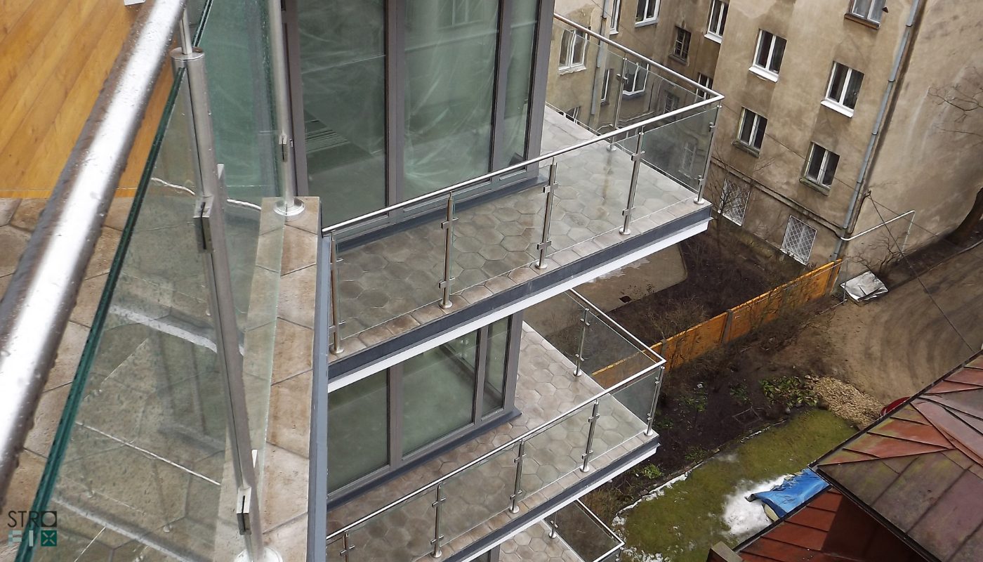 Stikls starp nerūsējošā tērauda stabiņiem ar stikla turētājiem uz dzīvokļu balkoniem